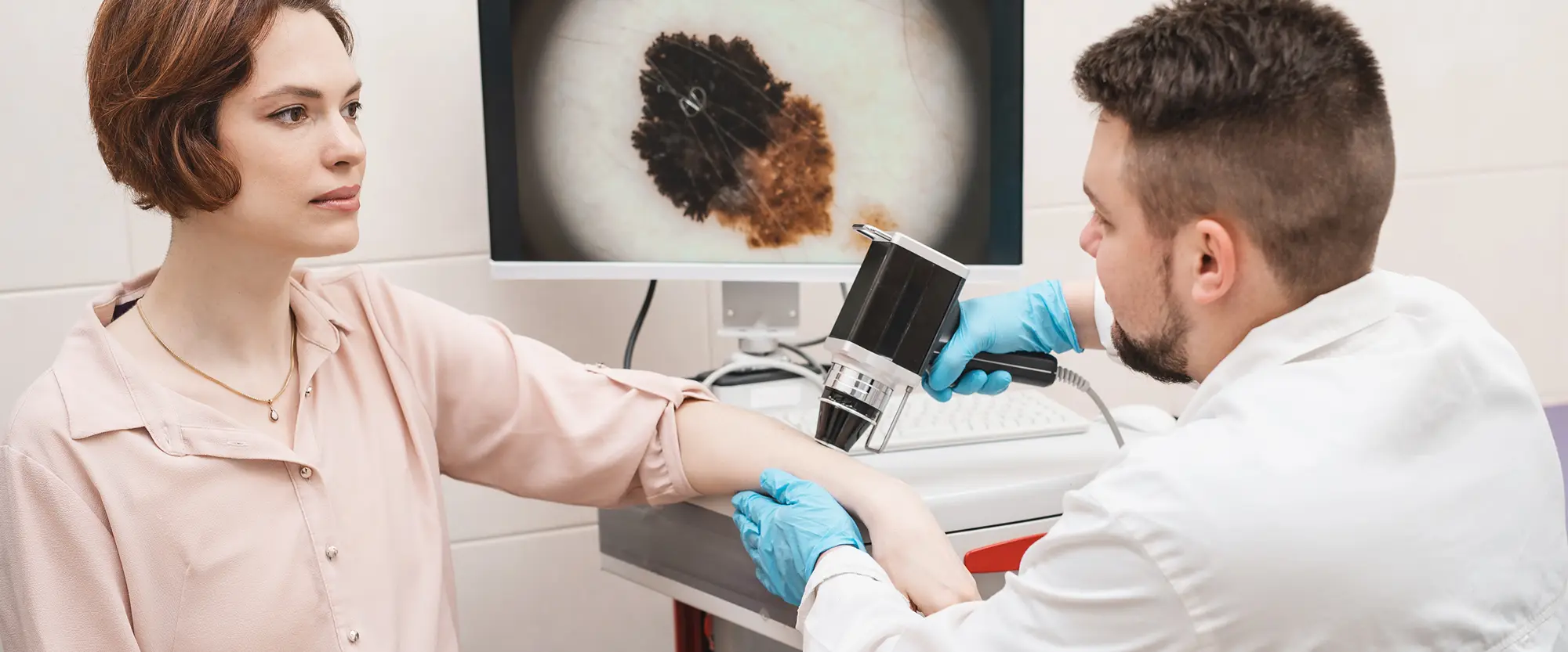 Badanie wideodermatoskopem w Lublinie. Lekarz bada kobietę przy użyciu wideodermatoskopu w gabinecie dermatologicznym Lykke Dermatologia